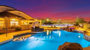 A swimming pool with a fountain, surrounded by a fence and outdoor seating. - Sweetwater Resort Estate Tennis Pool Spa Vball (Scottsdale)