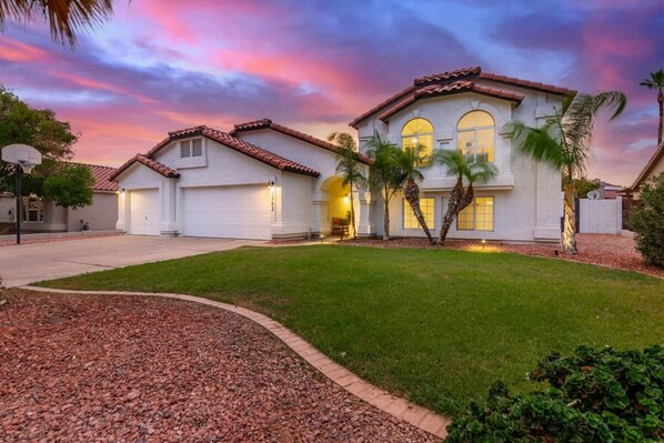 A two-story house with a white exterior, a red-tiled roof, and a well-maintained lawn. - 5BR Citrus Estate Sleeps 13 Free Htd Pool Gameroom (Mesa)