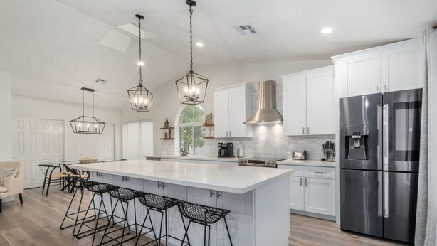 A modern kitchen with a large island, bar stools, stainless steel appliances, and pendant lighting. - 5BR Citrus Estate Sleeps 13 Free Htd Pool Gameroom (Mesa)
