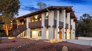 A two-story house with a covered patio, stone pathway, and a staircase leading to the upper level. - Serenity Retreat Sedona Hot Tub Games Firepit (Sedona)