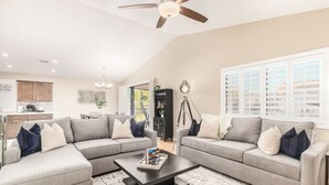 A modern living room with two grey sofas, a coffee table, and a ceiling fan. - Princess Retreat Private Pool Firepit Sleeps 12 (Mesa)