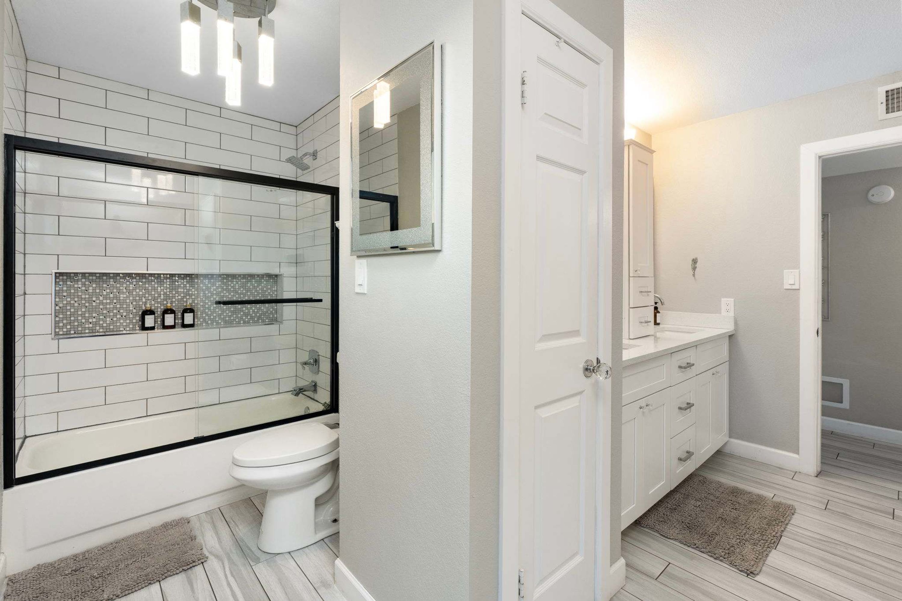 Een badkamer met douche, toilet en wastafel.