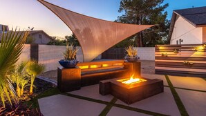 An outdoor patio with a fire pit, seating area, and plants. - Kings Lux Escape Free Htd Pool Cabana BBQ Firepit (Scottsdale)
