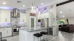 A modern kitchen with a central island, stainless steel appliances, and a sign that reads "EAT". - Kings Lux Escape Free Htd Pool Cabana BBQ Firepit (Scottsdale)
