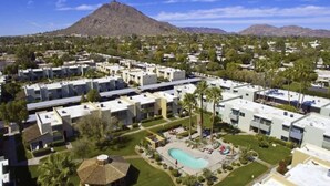 A residential area with modern apartment buildings, a swimming pool, and a mountain in the background. - Rustic Modern Townhouse Old Town 4 Heated Pools (Scottsdale)