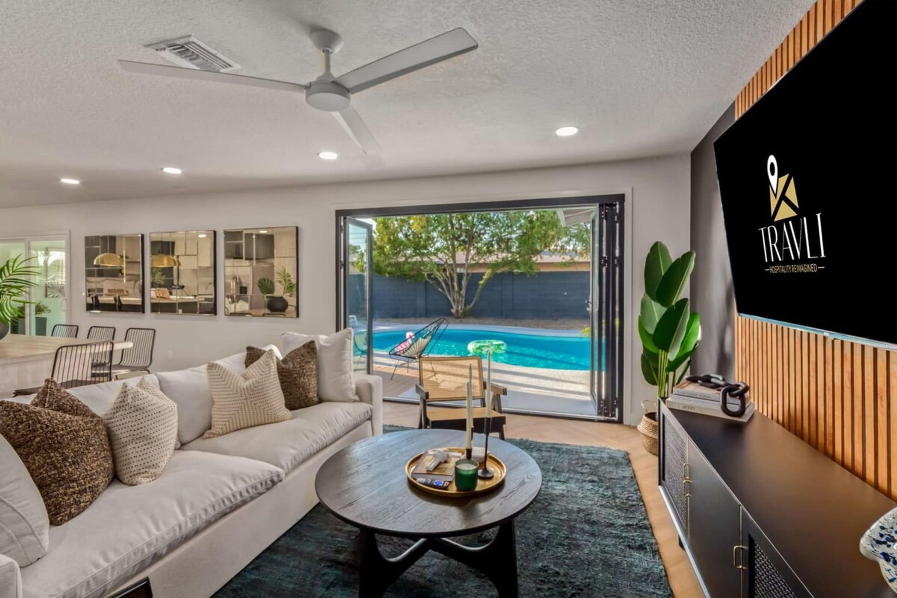 A modern living room with a sofa, coffee table, and a TV wall-mounted on the right.