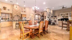 A spacious kitchen with a central island, wooden chairs, and a chandelier. - Desert Foothils Rustic Resort Oasis w Pool Spa (Scottsdale)