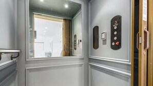 Un ascenseur moderne doté d’un panneau de commande, d’un miroir et d’une porte avec une poignée.