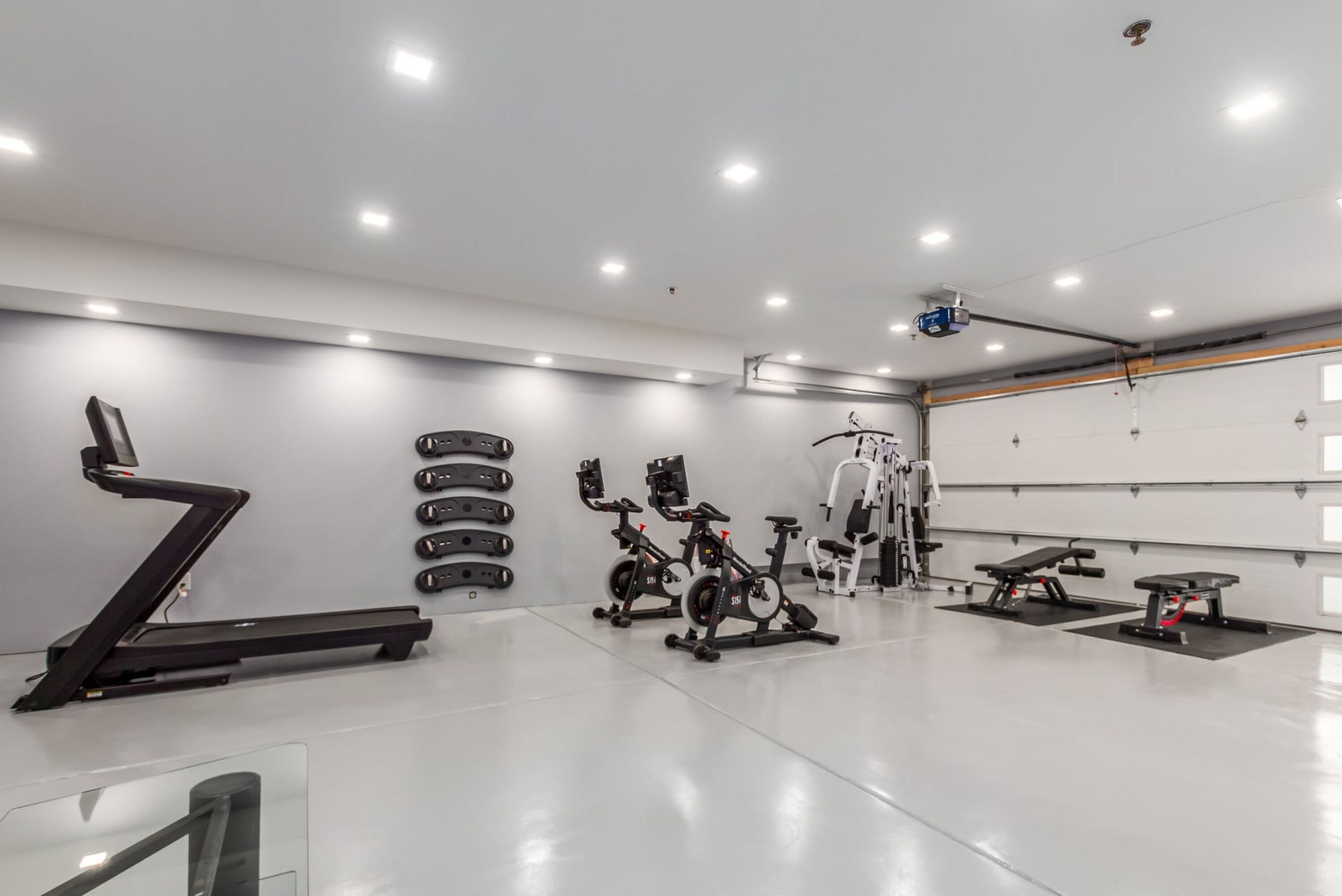 Ett modernt gym med ett brett utbud av träningsredskap, inklusive löpband, motionscyklar och styrketräningsmaskiner.