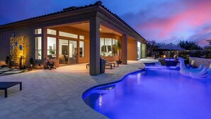 Ein modernes Haus mit Schwimmbad, Sitzgelegenheiten im Freien und einer Terrassenanlage.