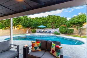 A covered outdoor area with a pool, lounge chairs, and a fire pit. - Modern Mesa Oasis Free Heated Pool Al-fresco Living (Mesa)