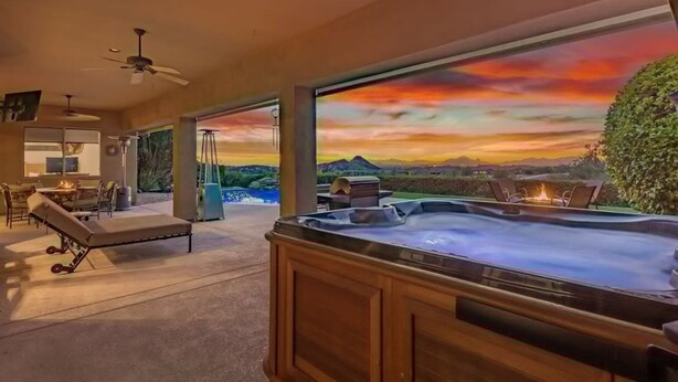 A spa area with a hot tub, lounge chairs, and a large window with a sunset view. - Sunset View Retreat Pool Spa Amazing Views (Scottsdale)