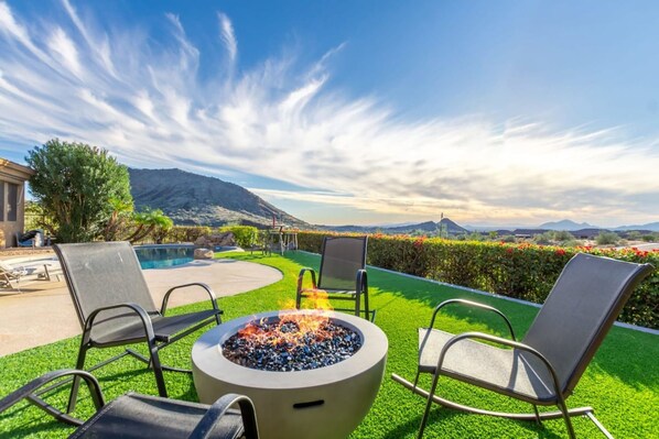 A poolside area with a fire pit, lounge chairs, and a view of mountains. - Sunset View Retreat Pool Spa Amazing Views (Scottsdale)