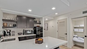A modern kitchen with a central island, built-in appliances, and a walk-in closet. - LUX City View Studio Old Town Gym Balcony (Scottsdale)