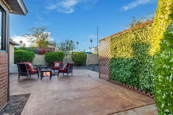 An outdoor patio with a fire feature, seating area, and a green wall with climbing plants. - Cozy SW Casa 5 Mins to DT PHX Sleeps 6 (Phoenix)