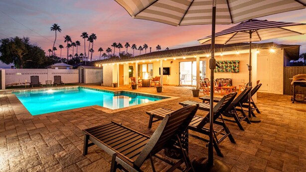 A poolside area with a swimming pool, lounge chairs, and umbrellas. - Palmhouse Pool BBQ 5 Mins to Old Town (Scottsdale)
