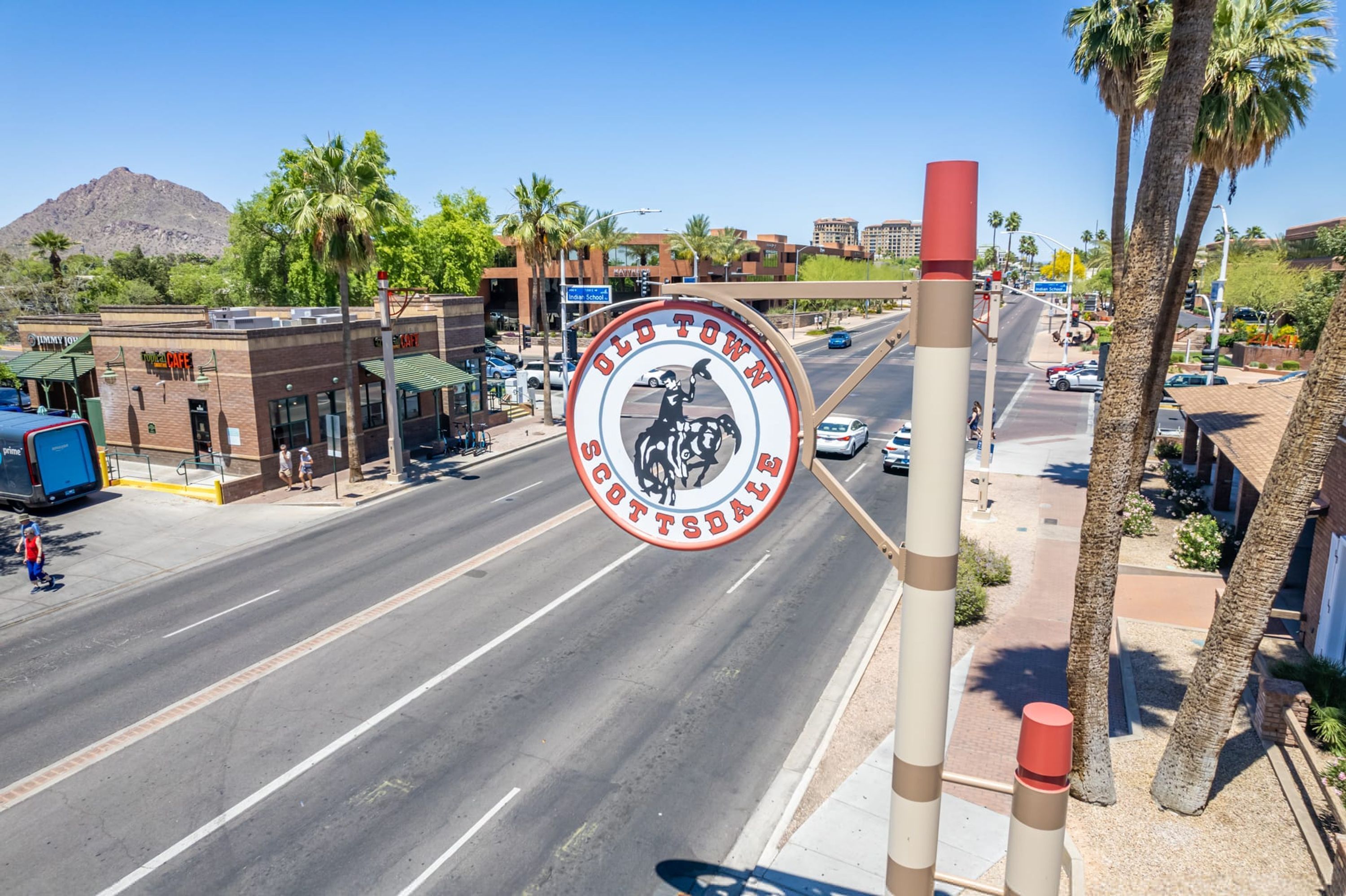 A street view with a prominent circular sign for Old Town Scottsdale, featuring a cowboy and horse.