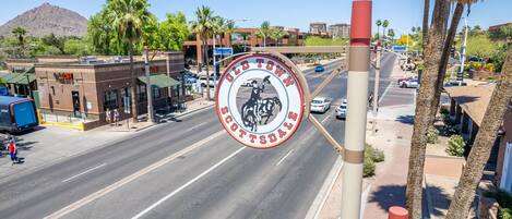 A street view with a prominent circular sign for Old Town Scottsdale, featuring a cowboy and horse.