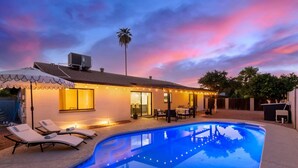 A modern house with a swimming pool, outdoor seating, and string lights. - Broadway Palms Private Pool Chef Kitchen Office (Tempe)