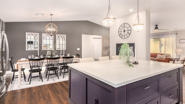 A modern kitchen with a large island, dark cabinetry, and pendant lighting. - Broadway Palms Private Pool Chef Kitchen Office (Tempe)