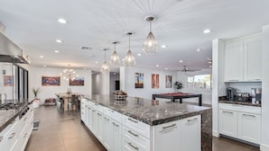 A spacious kitchen with white cabinetry, a large island, and pendant lighting. - Scottsdale s Largest Hot Tub Davenport Ranch Estate (Scottsdale)