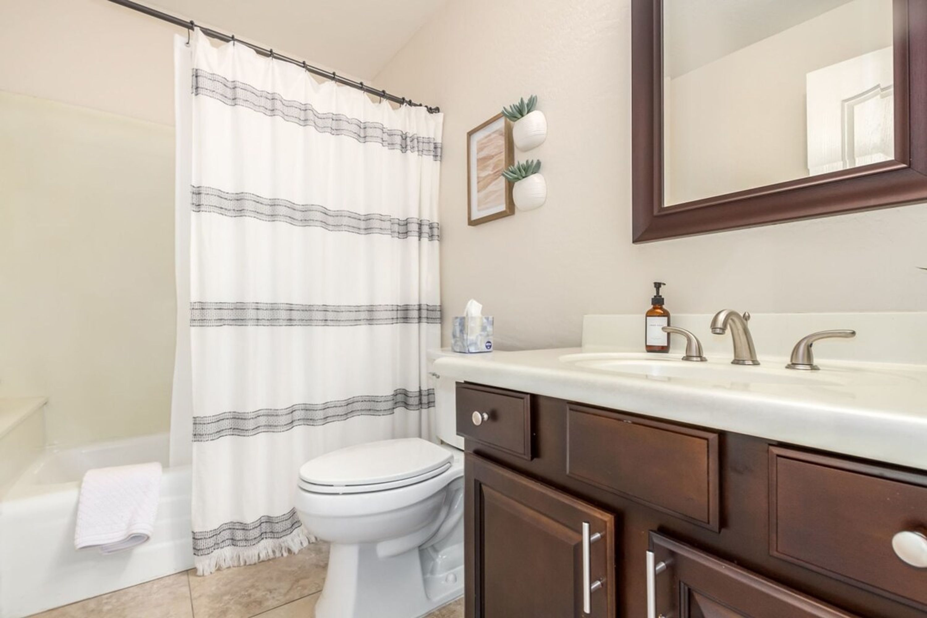 Un baño con cortina de ducha, inodoro, lavabo y armario.