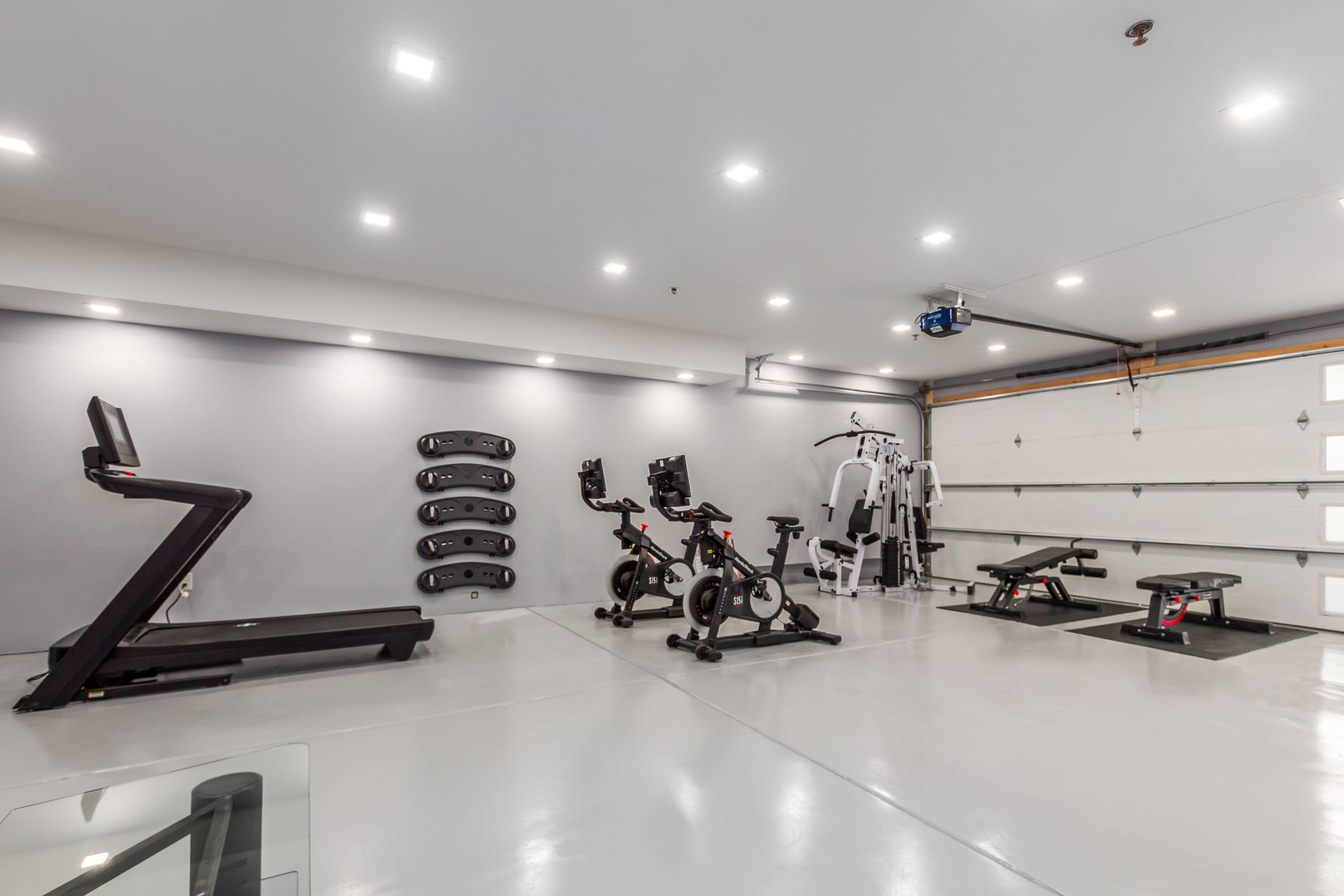 A modern gym with treadmills, stationary bikes, and weight machines.