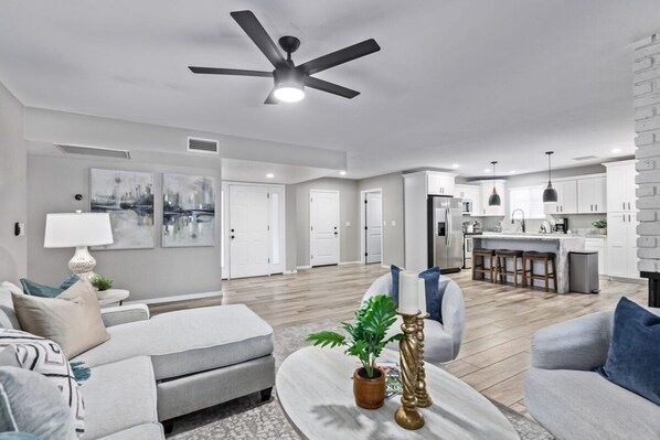 A modern living room with a sofa, coffee table, and a ceiling fan.