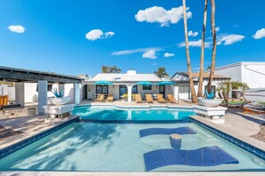 A swimming pool with lounge chairs and umbrellas, a barbecue area, and a view of a white building with a covered patio. - Scottsdale Palms Pickle-putt-swim-bocce Bbq-gym (Scottsdale)