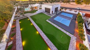 Propiedad residencial con piscina, cancha de tenis y garaje.