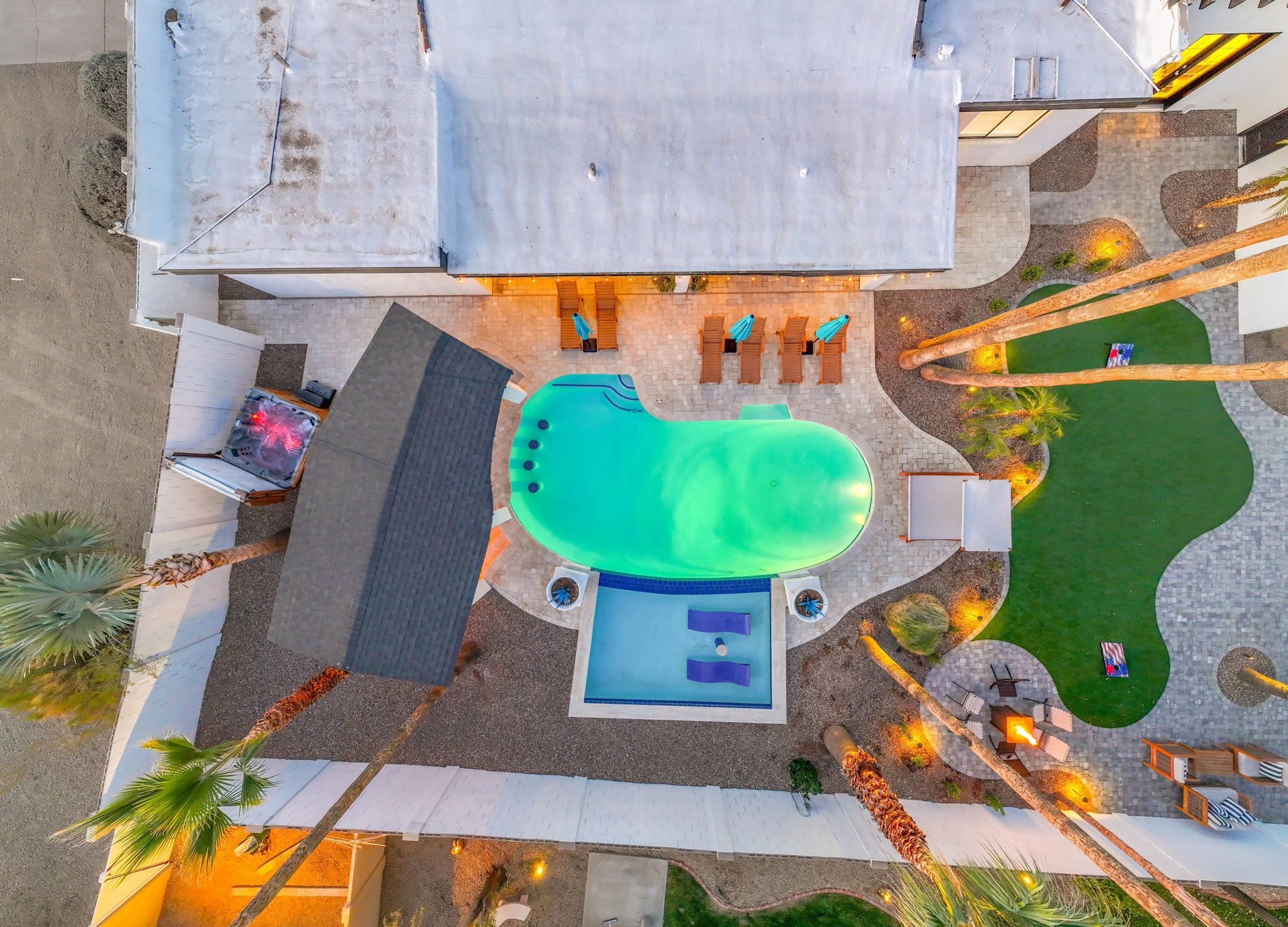 Un área de piscina en la azotea con un jacuzzi, sillas de descanso y una pequeña terraza.