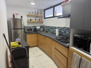 Prepare meals in the fully equipped kitchen with a refrigerator, oven, and gas stove.