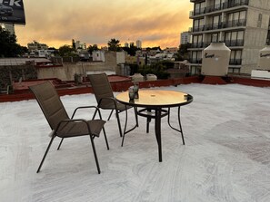 Relax on the rooftop terrace with a round table and two chairs.