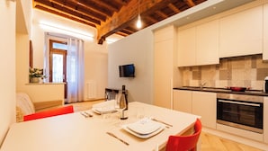 A modern kitchen with white cabinets, a built-in oven, and a herringbone-patterned floor. - La Dimora di Filippo (Cuneo)