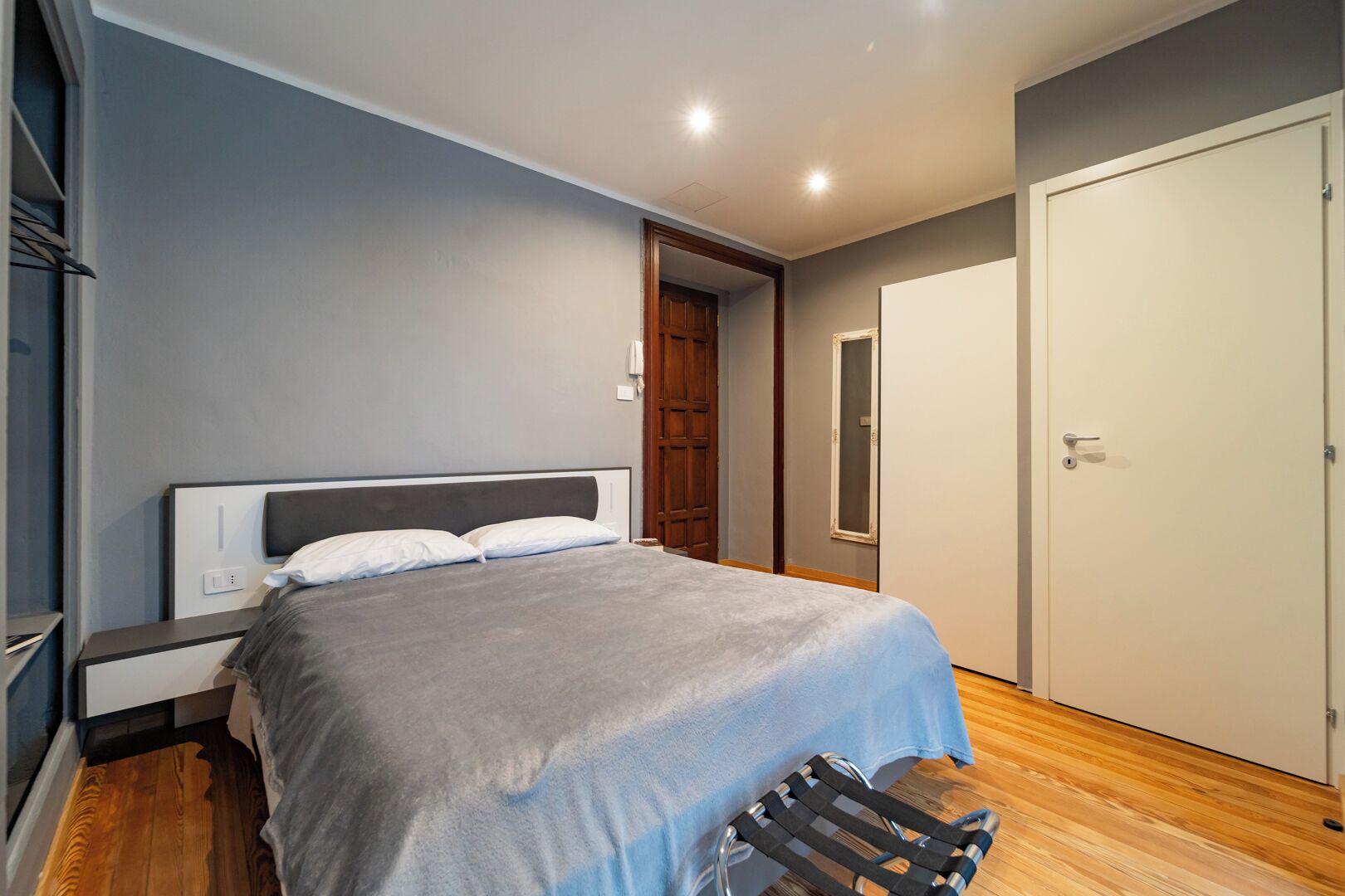 Ein Schlafzimmer mit Bett, Nachttisch und Kleiderschrank.
