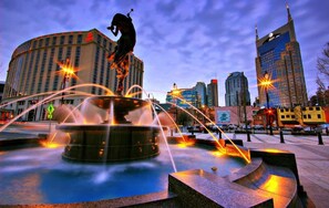 A cityscape with a fountain featuring a horse statue, surrounded by modern buildings. - 1 Country House Game Room BBQ Near Nashville TA (Franklin)