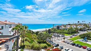 A coastal residential area with a view of the ocean, a parking lot, and a playground.