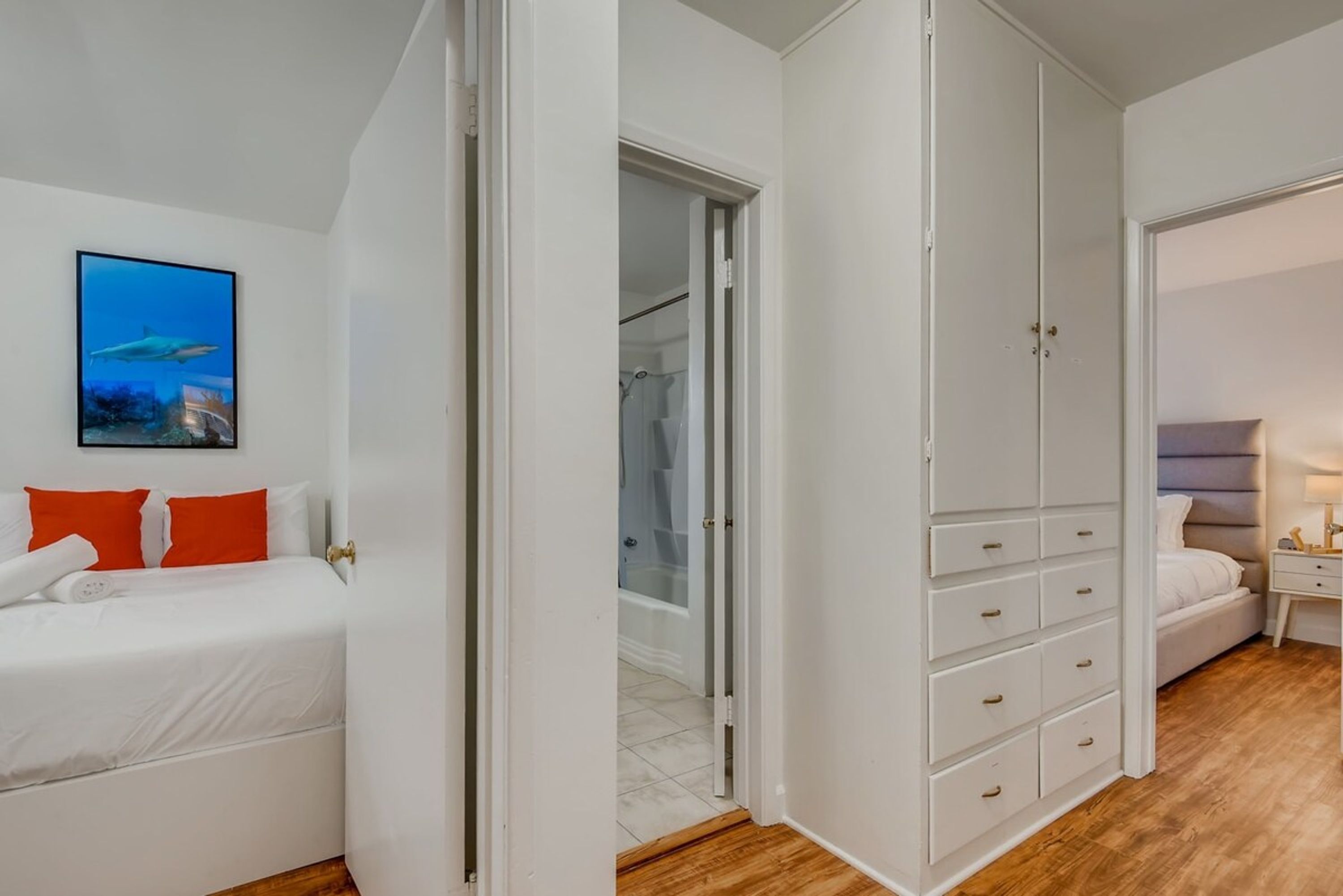 A bedroom with a bed, a wardrobe, and a bathroom visible through an open door.