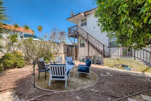 A patio area with outdoor furniture and a staircase leading to a second floor. - Walk to Beach - King Apt In 1 Area - AB (San Clemente)