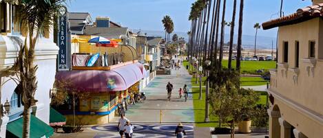 Una calle con el Balboa Inn, palmeras y un paseo peatonal.