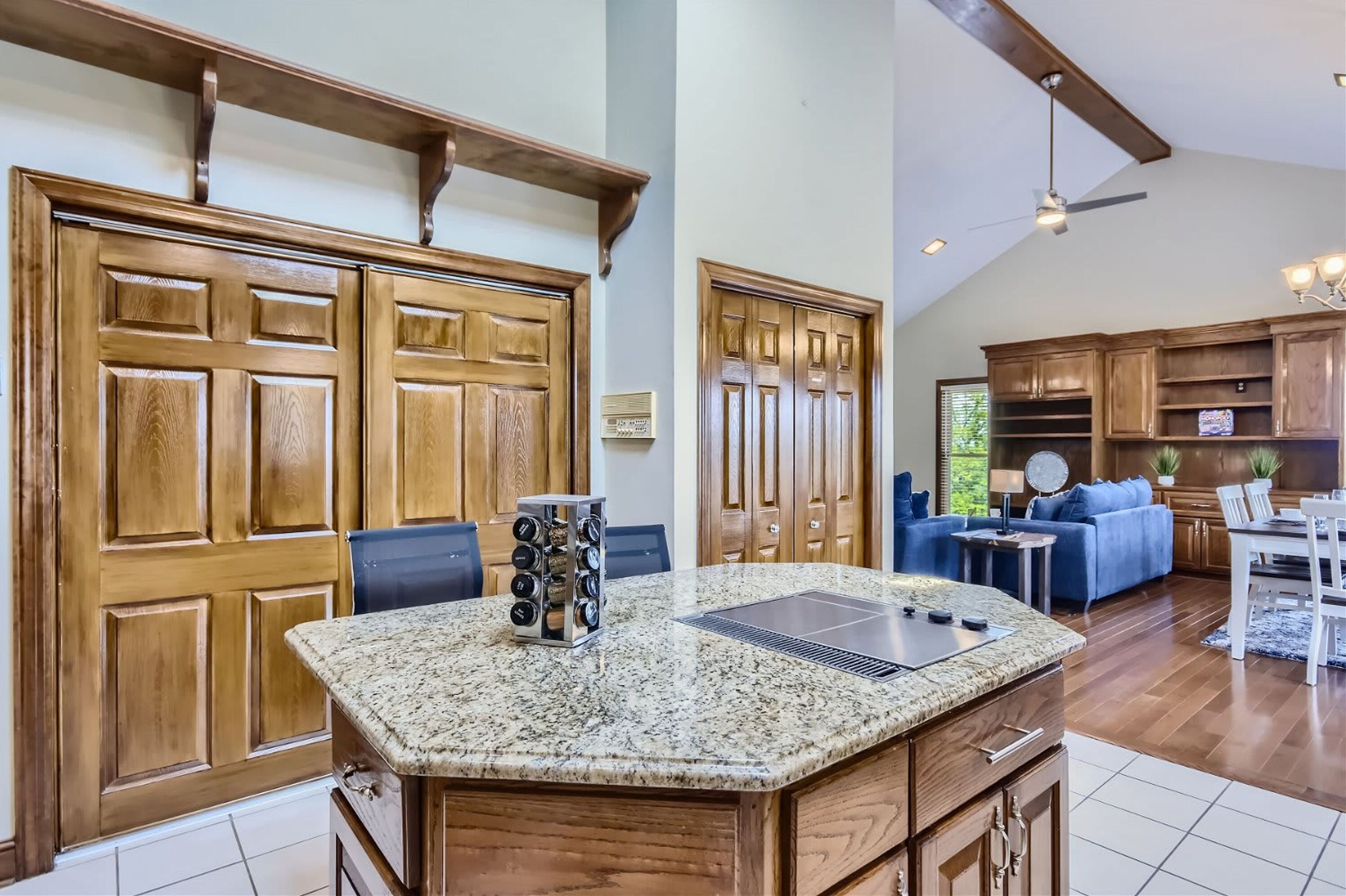A spacious kitchen with wooden cabinets, a granite countertop, and a built-in range hood.