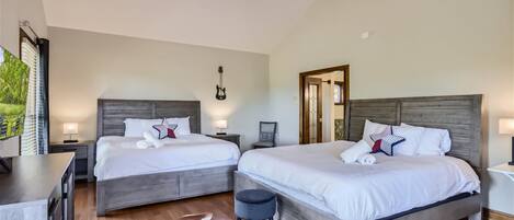 Un dormitorio con dos camas, un ventilador de techo y suelo de madera.