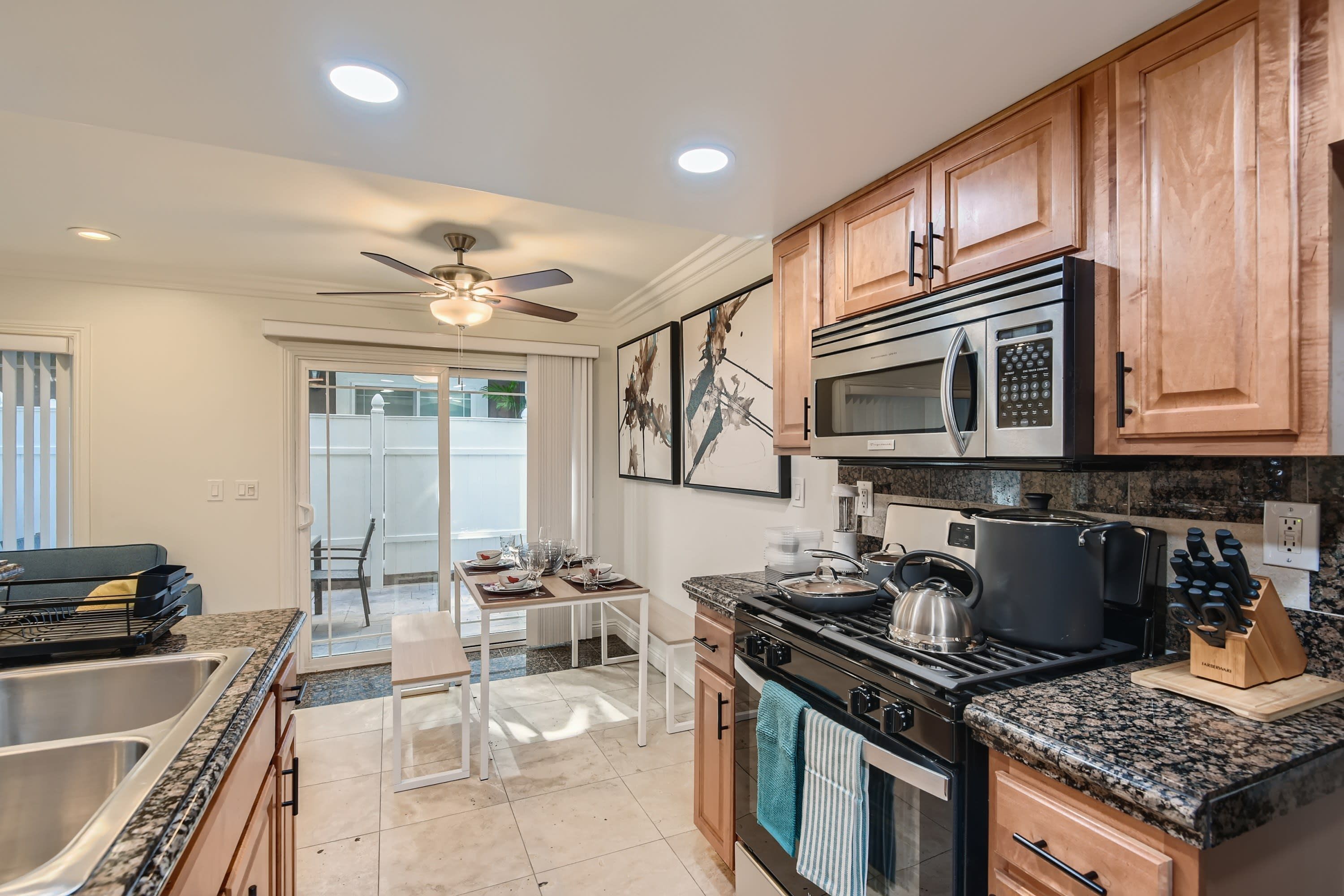A modern kitchen with granite countertops, stainless steel appliances, and wooden cabinets.