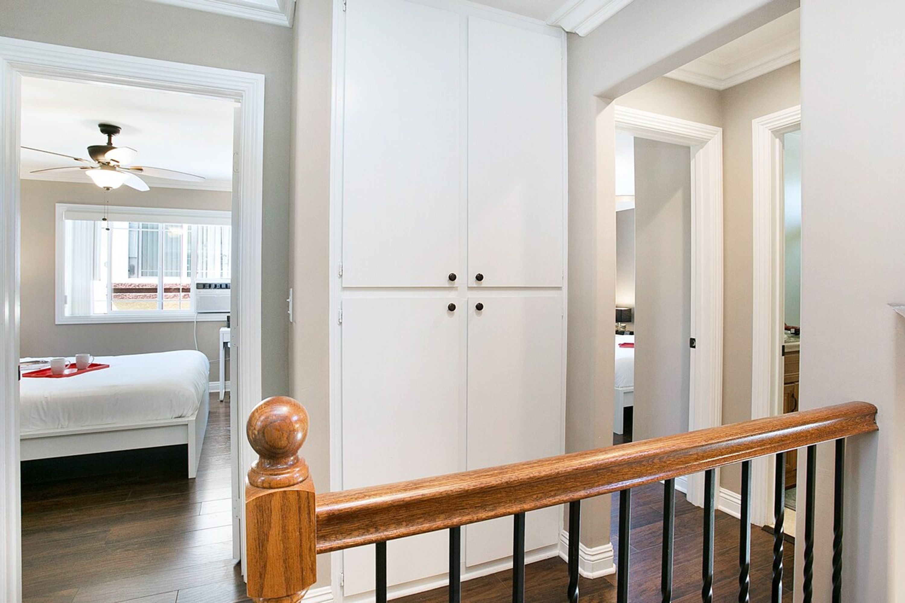 Une chambre à coucher avec un lit, une armoire et un ventilateur de plafond.