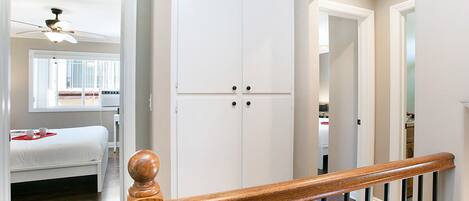 Une chambre à coucher avec un lit, une armoire et un ventilateur de plafond.