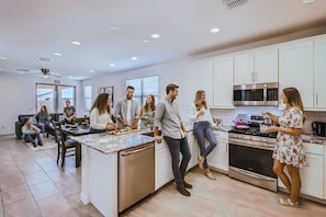 A modern kitchen with white cabinets, a central island, and stainless steel appliances. - NEW Awesome Phoenix Monthly 5BR (Tolleson)