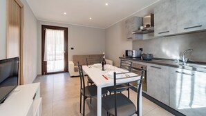 Une cuisine moderne avec un coin repas, comprenant une table blanche, des chaises et un canapé.