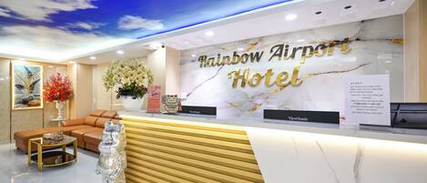 Una mesa de recepción con cubierta de mármol y un cartel que dice "Rainbow Airport Hotel".
