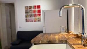 A kitchen with a wooden countertop, a white sink, and a stainless steel faucet. - The Landing, in the heart of downtown, a stone's throw from ferry and main square (Carloforte)