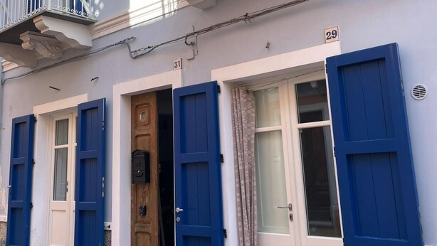 A building with blue shutters, a wooden door, and a balcony with white railings. - The Landing, in the heart of downtown, a stone's throw from ferry and main square (Carloforte)